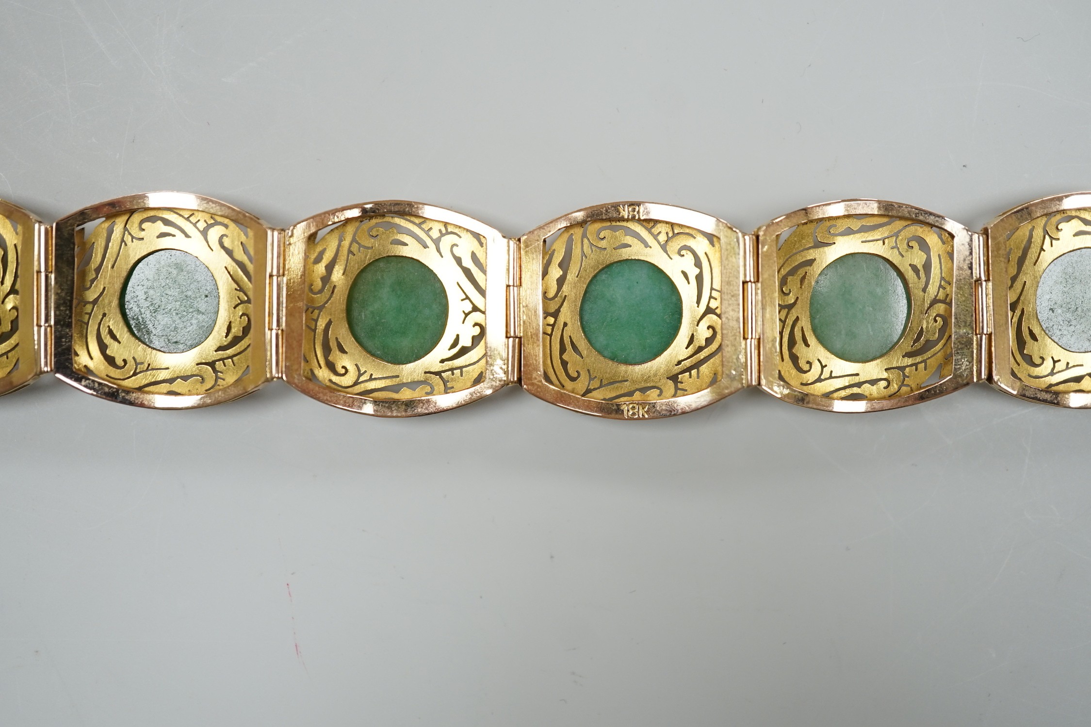 A continental 18k yellow metal and seven stone cabochon jade set bracelet, with pierced links, 18.5cm, gross weight 39.3 grams.